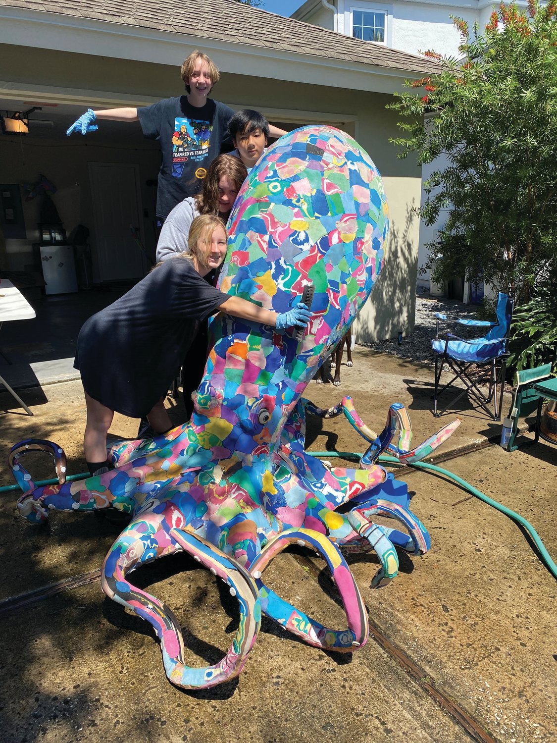 Four neighborhood children and Landrum Middle School students helped Ocean Sole clean a six-foot octopus statue made from recycled flip-flops.